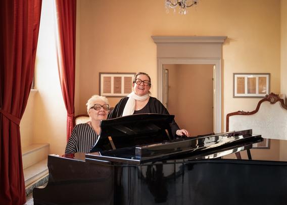 Marianna Brilla (left) and Lisa Paglin, founders of the New Voice Studio, next to their piano at the Osimo Opera House. | Teatro la Nuova Fenice.