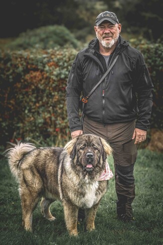 A colour photography (by Ruth Carden) of Nala, a Caucasian shepherd dog, standing with her owner Dermot, Taken on a wet day out in the west of Co. Galway, Ireland. Nala and Dermot are both looking towards the camera - looking majestic! 