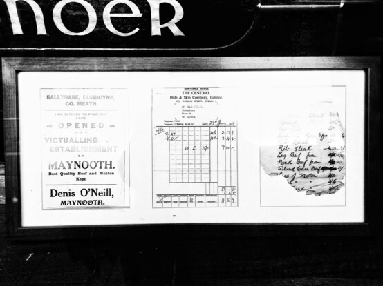 Black & white photo. A handwritten list of beef cuts (right), an invoice headed "The Central Hide and Skin Company" in Watling St for 55 pounds, 15 shillings and 9 pence (centre) and a notice saying "Ballynare, Dunboyne, Co. Meath. I beg to inform the public I have opened a victualling establishment in Maynooth. Best quality beef and mutton kept. Denis O'Neill, Maynooth" (left). 
