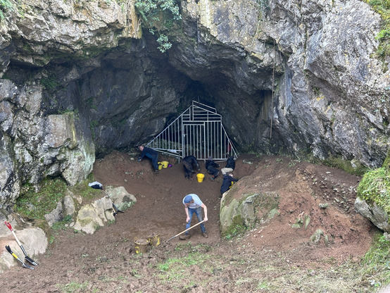 Archaeologists hard at work cleaning back inside the cave, ground sediment.