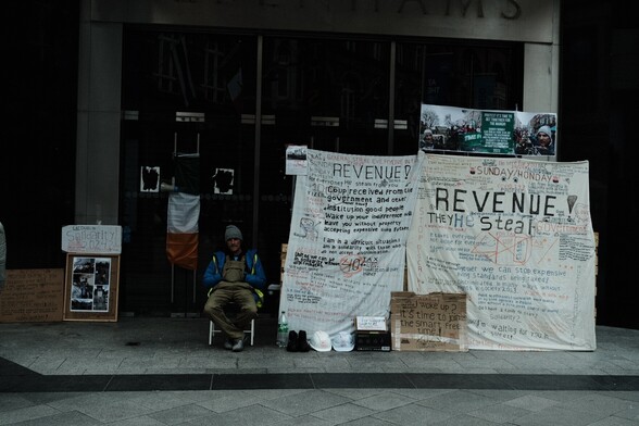 A solitary protester holding a myriad of signs