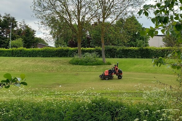 A council worker on a riding mower cutting the grass at Tolka Valley Pitch & Putt.