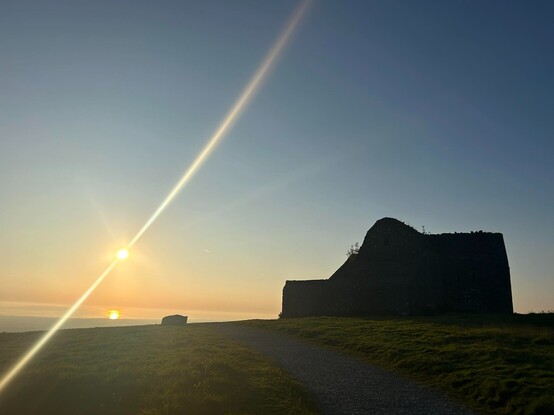 Silhouette of the Hellfire Club and the sunrise over Dublin Bay