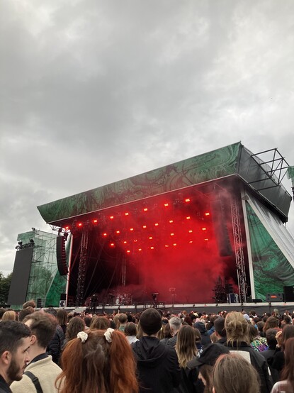 MUNA on stage at the Royal Hospital Kilmainham, Dublin, with different dramatic lighting. 