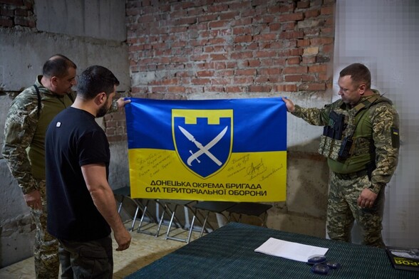 Working trip by Volodymyr Zelenskyy President of Ukraine  to #Donetsk and Zaporizhzhia regions

Zelensky looking at a military flag while 2 soldiers hold it up