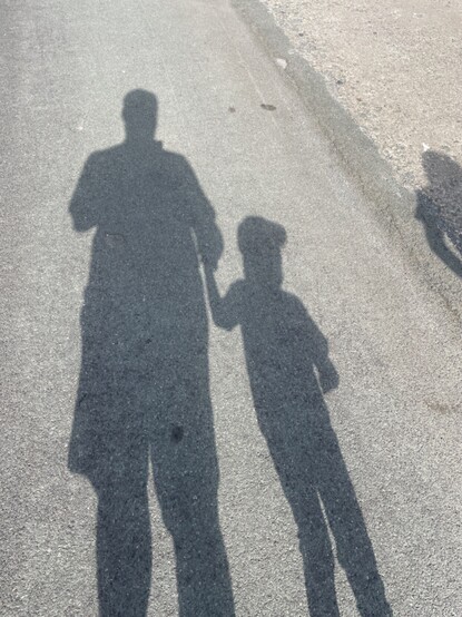 Shadow of father and son on tarmac