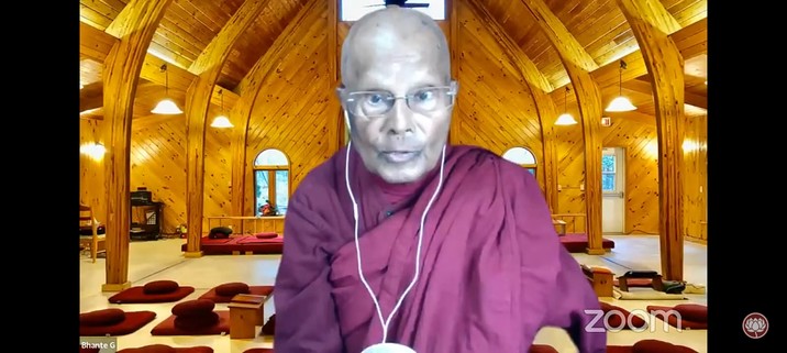 Bhante Gunaratana teaching Dhamma on YouTube with a virtual Bhavana Society hall in the background 
