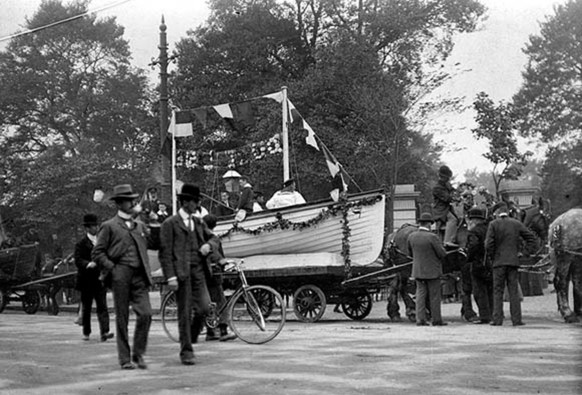 Men with horse-drawn float at St. Stephen's Green as part of an annual fund-raising flag day held by the Royal National Lifeboat Institution. 1897-1904. The National Library of Ireland. No known copyright restrictions.