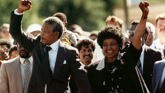 Photograph of Nelson and Winnie Mandela as he is released from prison. Both are holding up clenched fists.