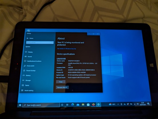 Linx 1010B tablet showing Windows 10 'About' information. The tablet has an Intel Atom CPU @ 1.33GHz and 2 GB RAM.