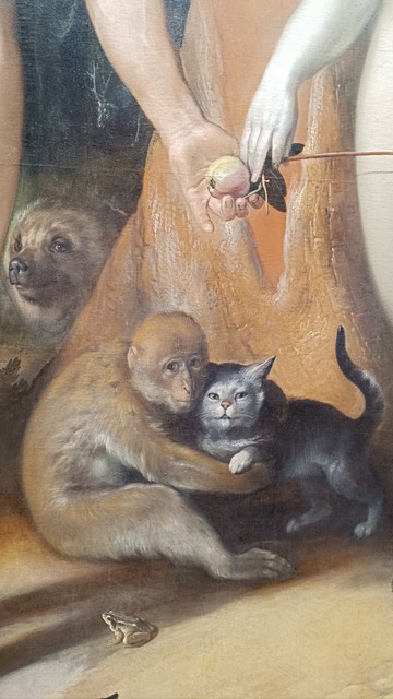 Detail from "The Fall of Man", painting by Cornelis van Haarlem. A young macaque hugs a grey kitty under the tree of knowledge. Above their heads the hands of Adam and Eve, touching. He's already holding the apple. A little frog sits next to the monkey's leg and the head of a bear appears on the left, behind the tree. 
