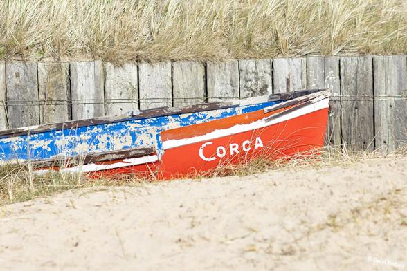 An old wooden boat on the beach. 