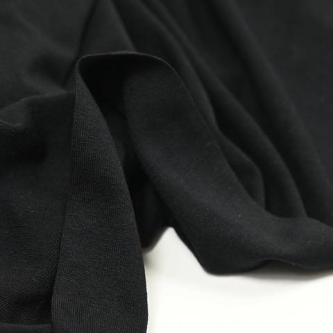 A store photo of black Jersey showing the fabric slightly bunched up on a white background 