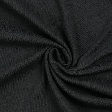 Black fabric laid out with a little twist in the middle.