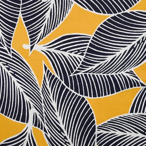 Warm yellow fabric with black leaves outlined in white.