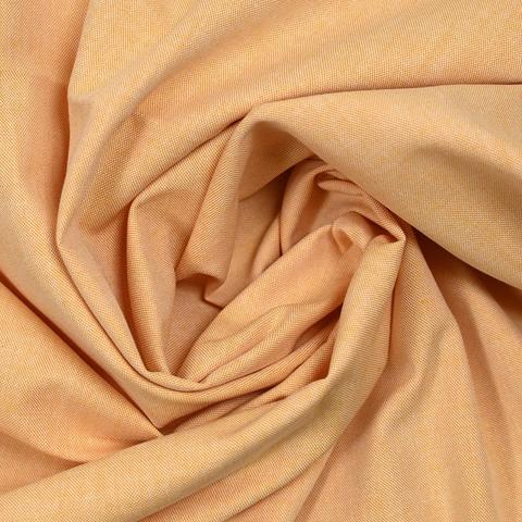 Oxford cotton in a pale orange photographed with a swirl in the middle 