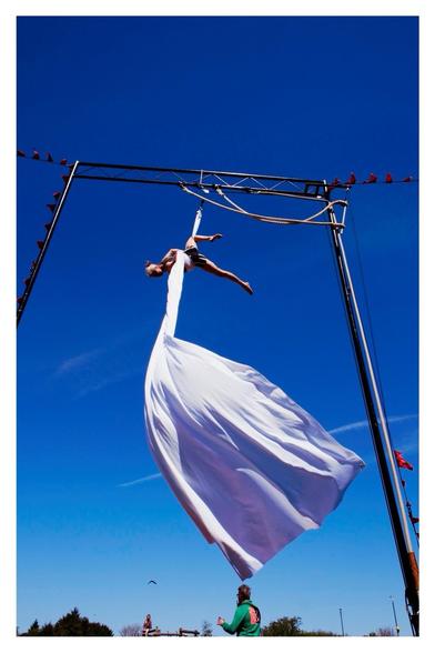 Suspended Tumble Circus performer and flowing fabric high above the playground.