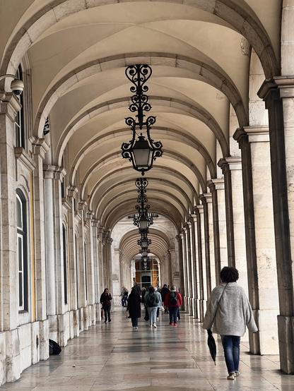 A long corridor of stone arches, with arches to the right.