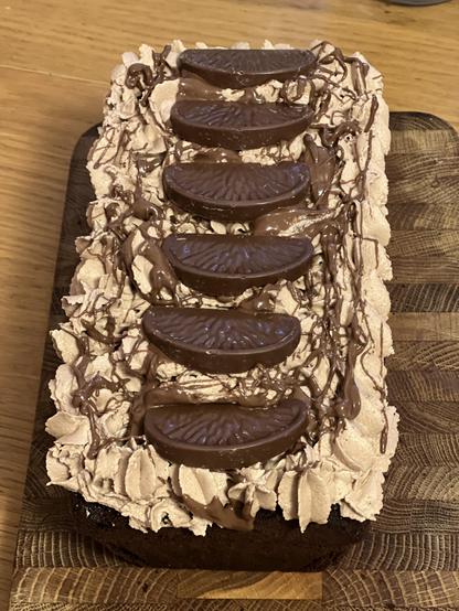 A chocolate loaf cake, iced and with slices of Terry’s chocolate orange on top of the icing.