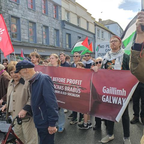 PBP activists marching in Galway City with a banner and Palestine flags