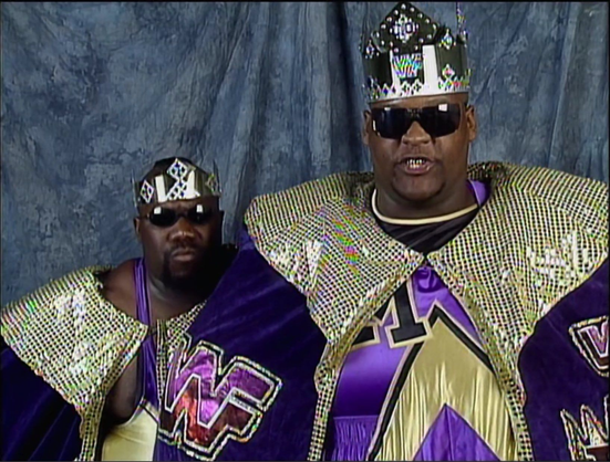"Men on a Mission"
Mo on the left and Mabel on the right. 
They are both dressed in a robe and a crown as Mable was King of the Ring. 
At this time, Mo was called "Sir Mo"