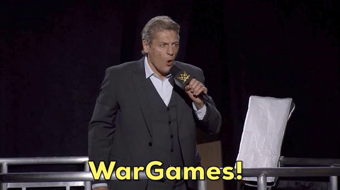 William Regal shouting "War Games" into a microphone. 