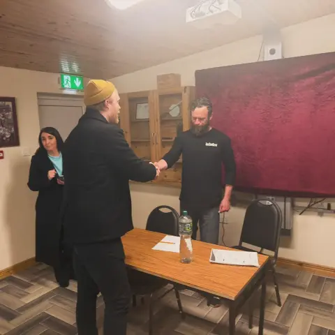 Denman Rooke in the Maam Community Centre for a public meeting