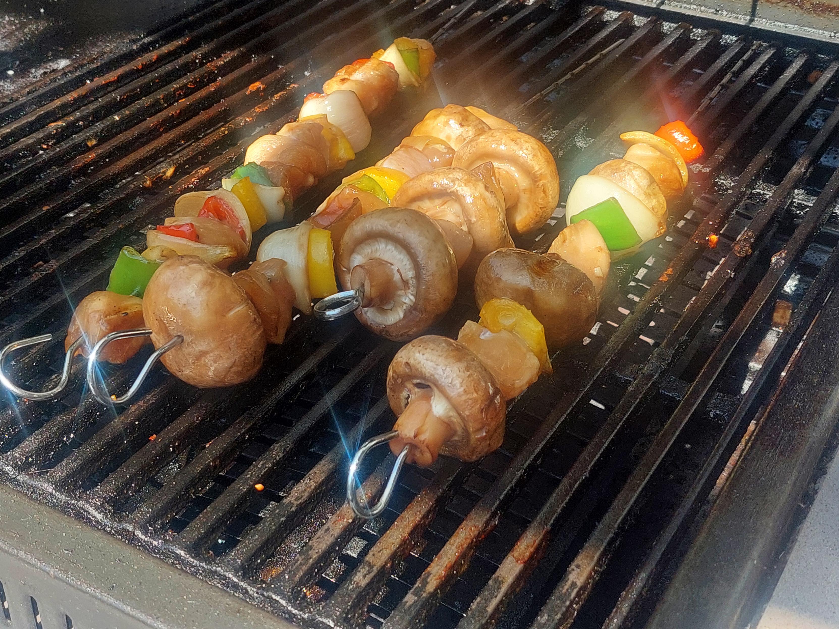 4 kebabs cooking on a BBQ
