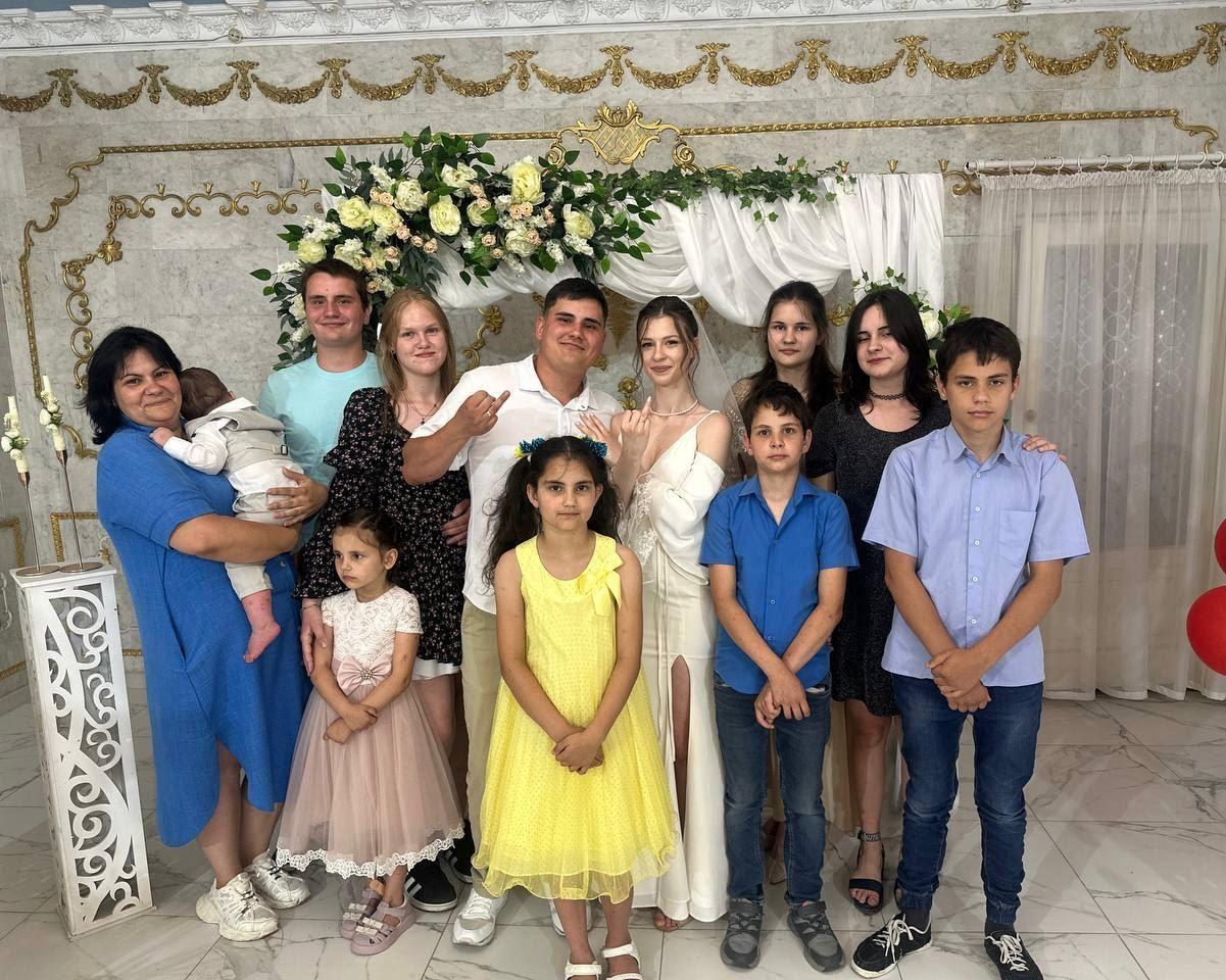Group photo of the Voronov family, including parents Olena and Artem, their seven children (Mark, Dominika, Zakhar, Azariy, Ilay, Federica, Emilia, Viorika), and their one-and-a-half-year-old grandson Artem. The family is dressed in formal and colorful attire, posing together in a decorated indoor setting with floral arrangements and ornate golden wall accents. This image represents the ordinary Ukrainian family tragically targeted by a russian ballistic missile strike in Radushne, Dnipropetrovsk region, as described by President Zelenskyy. The attack destroyed their home, killing Olena, Artem, Mark, Azariy, and Emilia, with others' fates still unconfirmed. The photo underscores the human cost of russia's war and the urgent need for global support to protect families like theirs.

Source: President Zelenskyy 
Alt text generated with Vibe (Mistral AI)