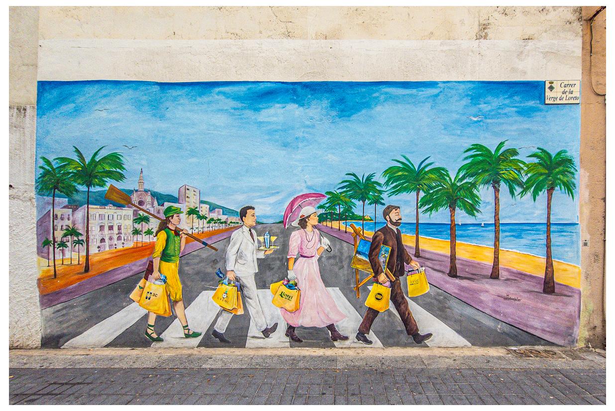 A mural of four people crossing a road on a pedestrian crossing.