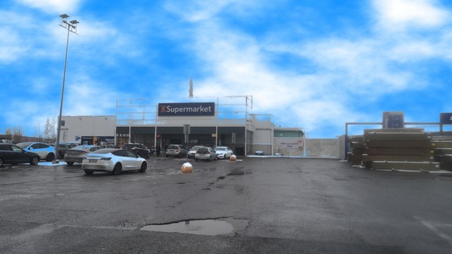 Takatalvipäivän näkymä K-Supermarket Nekalaan sen parkkipaikalta. Taivas marketin yllä on kirkkaan sininen, kevyesti pilviä.
