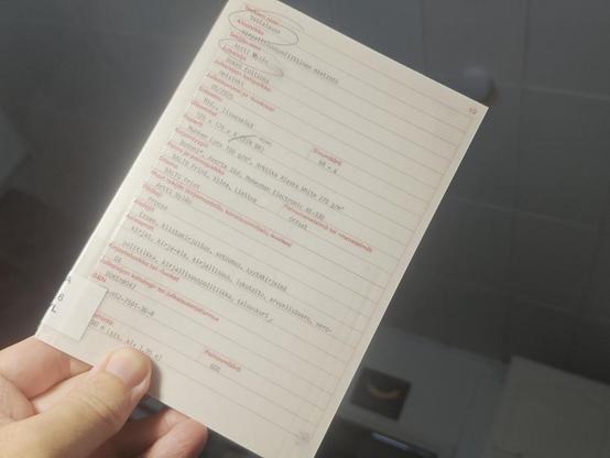 B6-kokoinen kirja kädessä. Kantena on lomake, jolla kuvataan kirjan tietoja, kuten tekijä, julkausutiefot, painotiedot, luokittelu jne...
