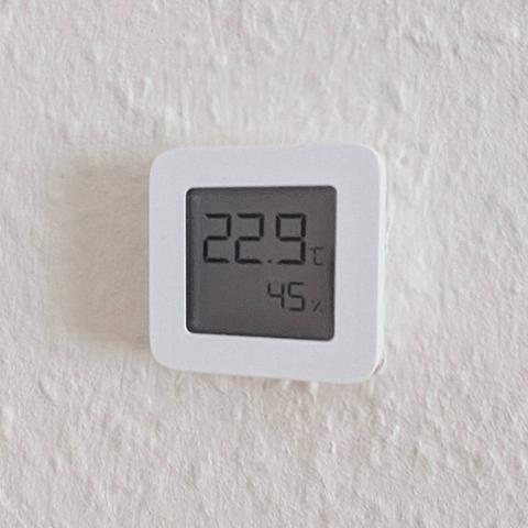 The original thermometer, a small white box with an LCD screen at the front, showing room temperature and relative humidity.