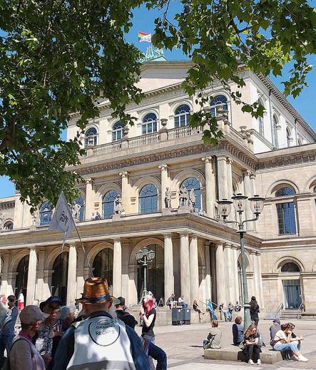 Oper Hannover in der Sonne, unten links Teilnehmender Omas gegen Rechts, auf dem Dach der Oper die Regenbogenflagge.
