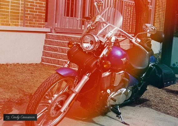 Moto dans un arc en ciel de lumières. Photographie par Cindy Cinnamon