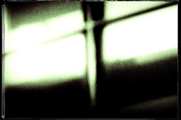 Surreal composition of windows in blur with retro green yellow tint - the frames of the windows resembles a crucifix.