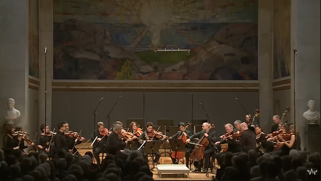 The Norwegian Chamber Orchestra in front of a large painting
