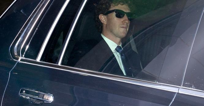 Mark Zuckerberg wears sunglasses and sits in the back of an SUV.
