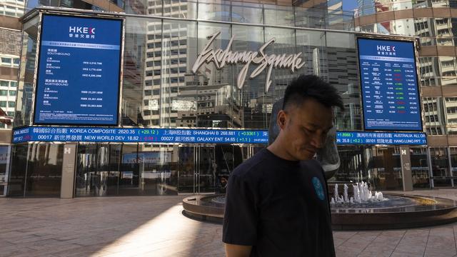 Un homme marche devant la Bourse de Hong Kong.