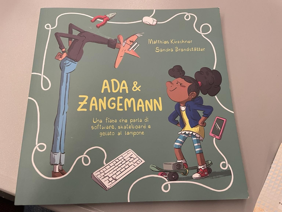 La copertina di un libro illustrato intitolato "Ada & Zangemann", che parla di software, skateboard e gelato al lampone.  Sono raffigurati un uomo capovolto con le gambe lunghe e una bambina di carnagione scura con i capelli ricci che sta in piedi su uno skateboard.  Sullo sfondo ci sono una tastiera e un cavo disegnato.