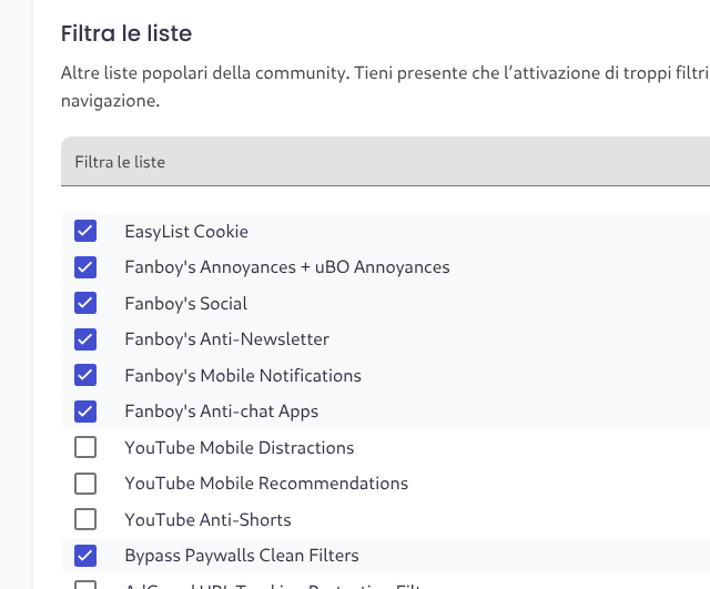 L&#39;immagine mostra una sezione di un sito web o di un&#39;applicazione che permette di filtrare le liste di contenuti. Il titolo &quot;Filtra le liste&quot; è in grassetto e in nero, seguito da una descrizione in italiano: &quot;Altre liste popolari della community. Tieni presente che l&#39;attivazione di troppi filtri può influire sulla navigazione.&quot; Sotto, c&#39;è un campo di ricerca con l&#39;etichetta &quot;Filtra le liste&quot; in grigio chiaro. La lista di opzioni è suddivisa in due colonne. Le opzioni selezionate sono evidenziate con una casella a spunta blu e un segno di spunta. Le opzioni selezionate includono: EasyList Cookie Fanboy&#39;s Annoyances + uBO Annoyances Fanboy&#39;s Social Fanboy&#39;s Anti-Newsletter Fanboy&#39;s Mobile Notifications Fanboy&#39;s Anti-chat Apps Bypass Paywalls Clean Filters Le opzioni non selezionate sono: YouTube Mobile Distractions YouTube Mobile Recommendations YouTube Anti-Shorts L&#39;interfaccia è pulita e organizzata, con un design minimalista che facilita la navigazione.