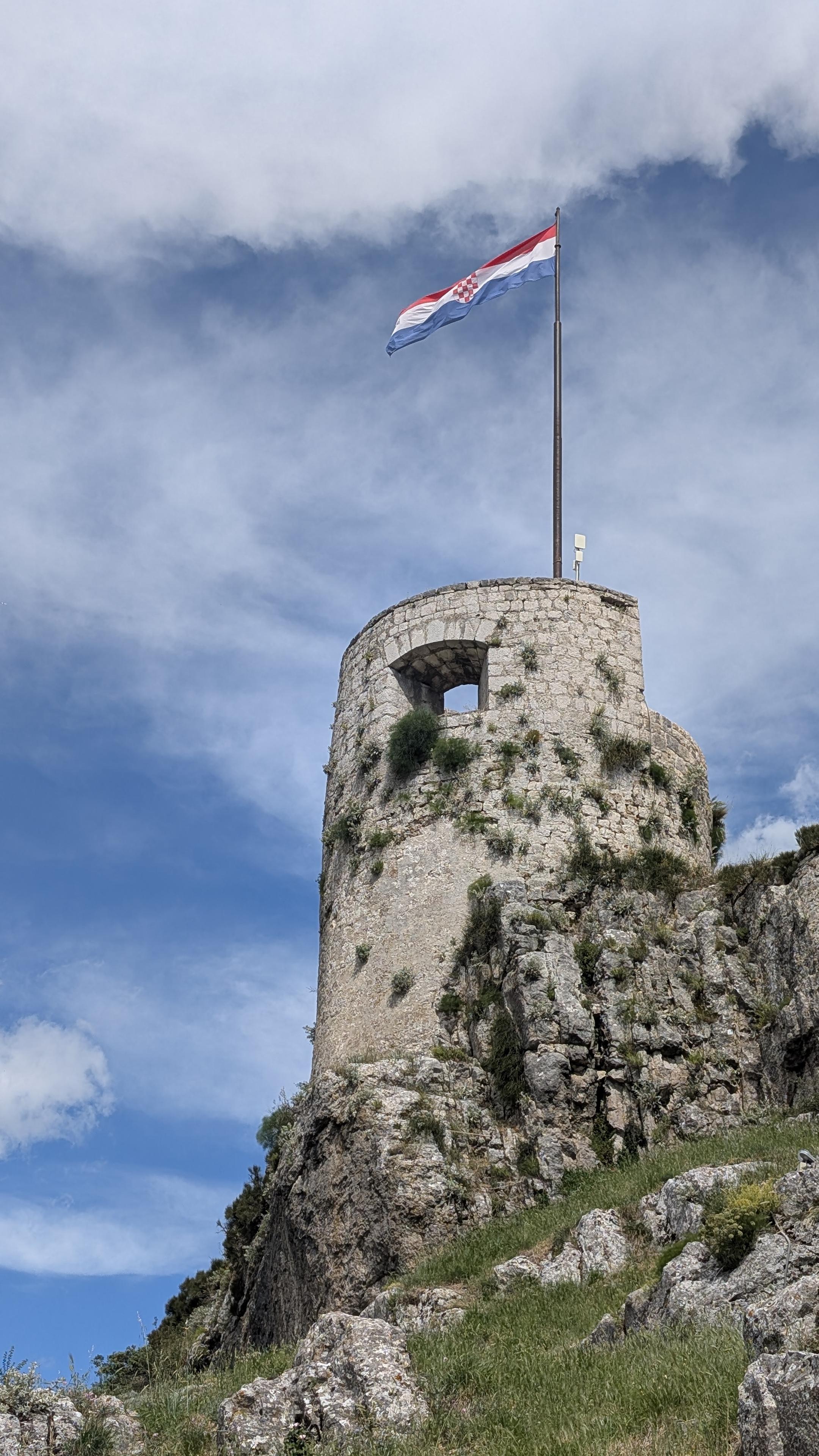 Antica torre di avvistamento del Castello di Klis, con la bandiera croata agitata dal vento