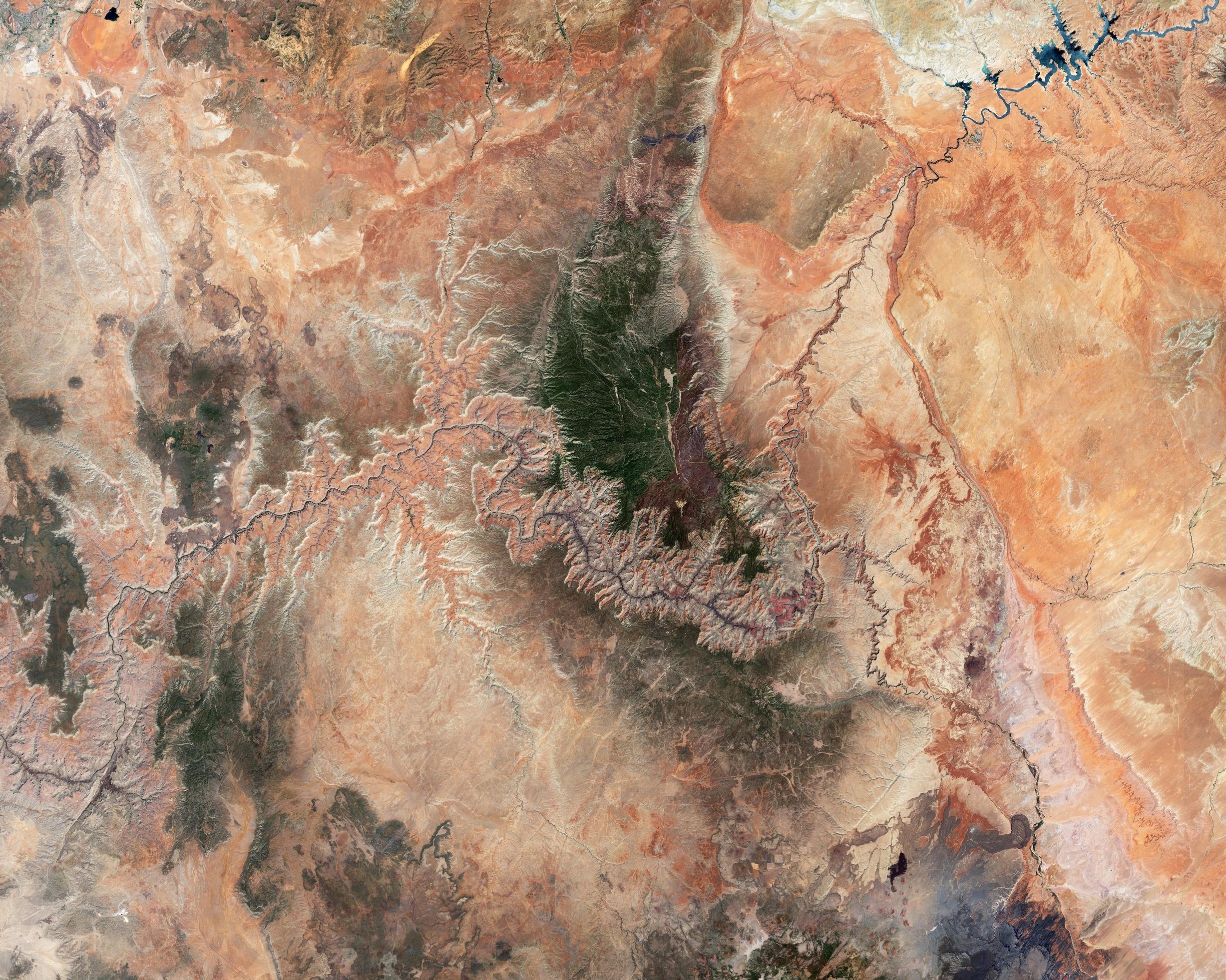Questa valle fluviale, situata nella parte sud-occidentale dell’altopiano del Colorado, si estende per circa 443 km e raggiunge i 29 km di larghezza. Le pareti del canyon, le strutture rocciose, gli antichi flussi di lava, i mesa, i burroni, la topografia a gradoni e i colori brillanti testimoniano il suo prezioso patrimonio geologico.

Sebbene il Grand Canyon sia il risultato di diversi processi combinati, è stato formato principalmente dall’azione erosiva del fiume Colorado, iniziata circa sei milioni di anni fa. Altri fattori contribuenti includono il vulcanismo, la deriva dei continenti e il clima semi-arido.

Mentre l’erosione idrica scolpiva questo maestoso paesaggio geologico, rivelava strati e strati di rocce esposte che ci forniscono una cronologia profonda degli eventi geologici. Poiché alcune delle rocce più antiche della Terra si trovano sul fondo del canyon, si dice che esso sia “profondo un miliardo di anni“.

In questo confronto, il canyon è la formazione rocciosa che attraversa il centro delle immagini, visibile con tonalità arancioni