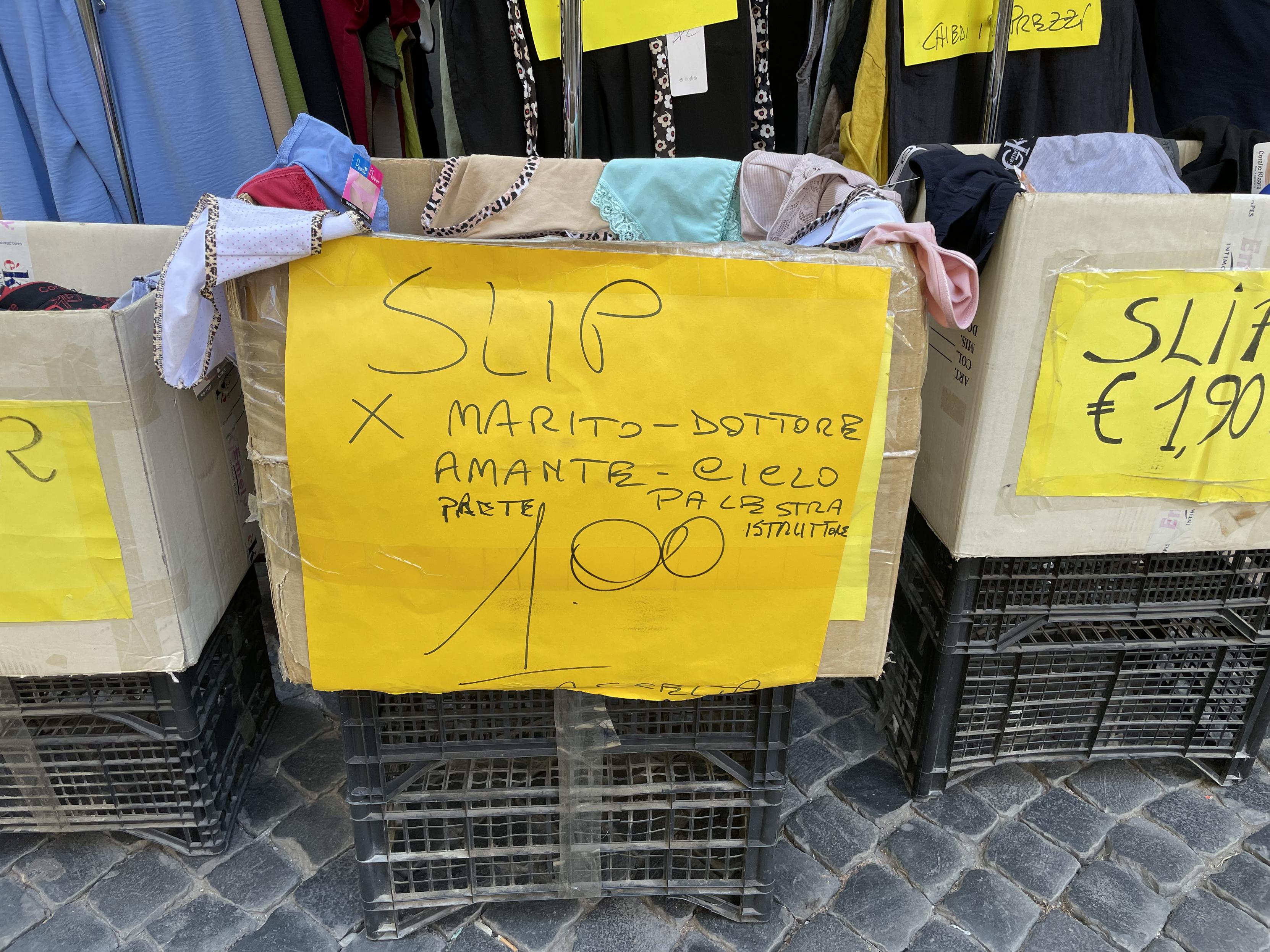Cassetta piena di mutande di un negozio di Viterbo.
Sopra c’è un cartello giallo con una scritta a penna che recita:
SLIP x MARITO - DOTTORE - AMANTE - CICLO - PRETE - PALESTRA istruttore
1.00 €