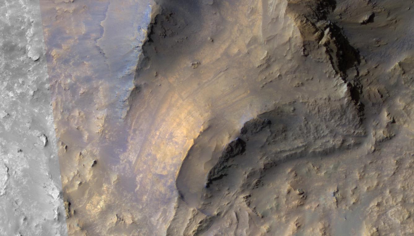 Direttamente a nord-ovest di questa struttura si trova un substrato roccioso sollevato con una stratificazione intatta ben distinguibile, una caratteristica comune osservabile nei sollevamenti centrali dei crateri da impatto situati in prossimità di Valles Marineris.

Comprendere l’origine di ciascuna unità rocciosa e il modo in cui queste siano state successivamente esposte durante il processo d’impatto rappresenta un problema complesso, che richiede l’integrazione di diversi set di dati ottenuti dal telerilevamento di Marte.