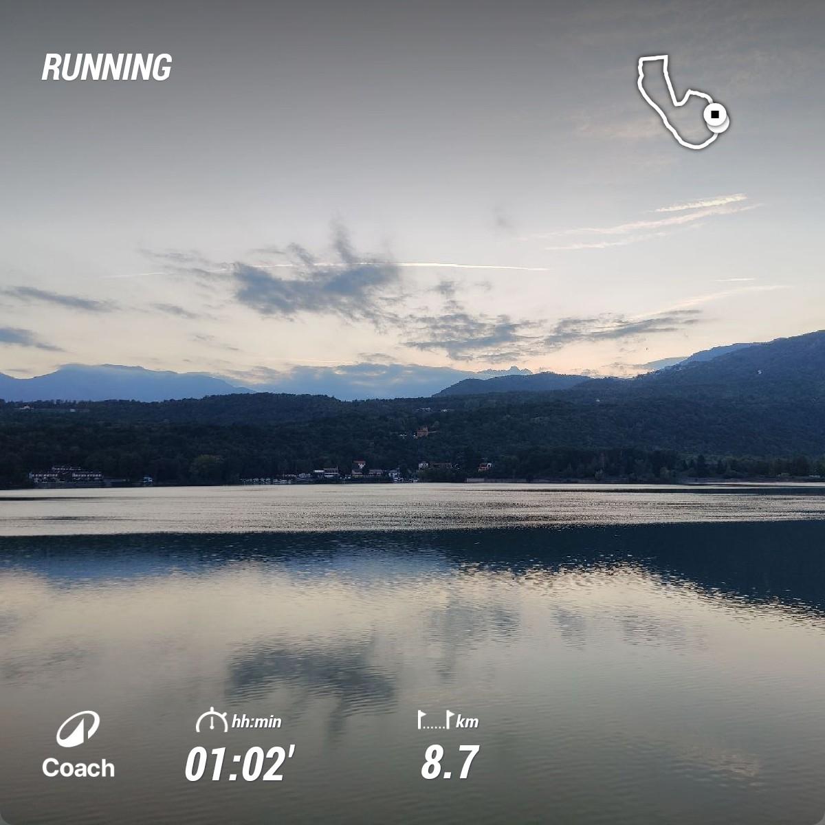 Foto del Lago Grande di Avigliana con alcune statistiche della mia ultima corsa.
Il cielo del tramonto è molto luminoso, in forte contrasto con le poche nuvole e con le montagne.
Il riflesso sull'acqua è tormentato da un po' di vento.