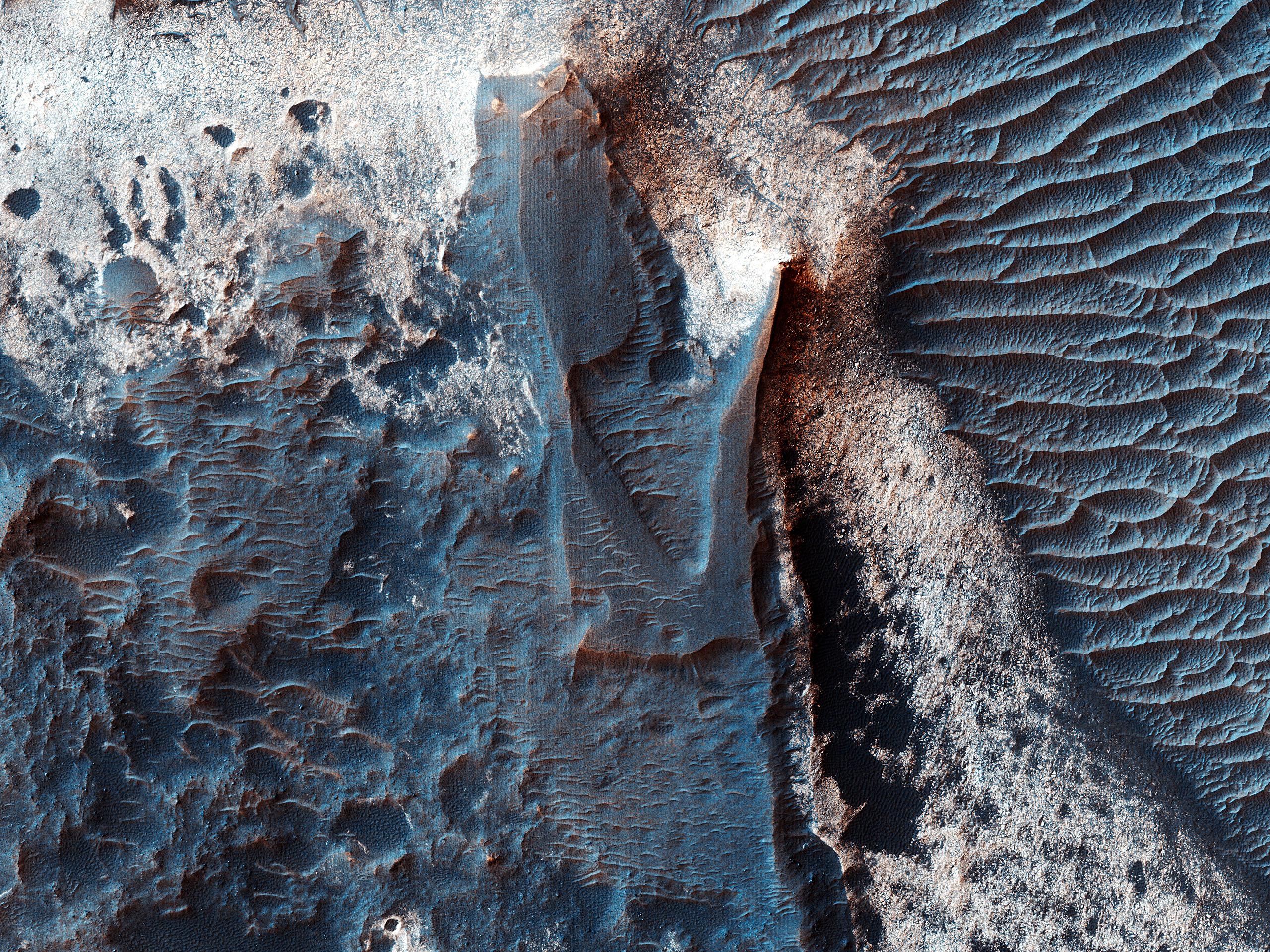 È noto fin dagli anni '70, quando le sonde Viking scattarono le prime immagini di Marte, che nella parte centrale di Valles Marineris sono presenti grandi cumuli (spessi diversi chilometri) di depositi di colore chiaro. Immagini più recenti di Marte ad alta risoluzione, tra cui questa di Melas Chasma, mostrano che anche le rocce delle pareti di Valles Marineris contengono depositi simili, sebbene più sottili, di colore chiaro.

I dati spettrali dello strumento CRISM indicano che i cumuli più grandi sono composti da solfati. Anche alcuni dei depositi presenti nelle rocce delle pareti sono costituiti da solfati, mentre altri contengono argille o miscele di diversi tipi di materiali idrati, il che suggerisce che molteplici processi acquosi, forse avvenuti in momenti diversi all’interno di Valles Marineris, abbiano dato origine alla varietà di depositi che osserviamo oggi.