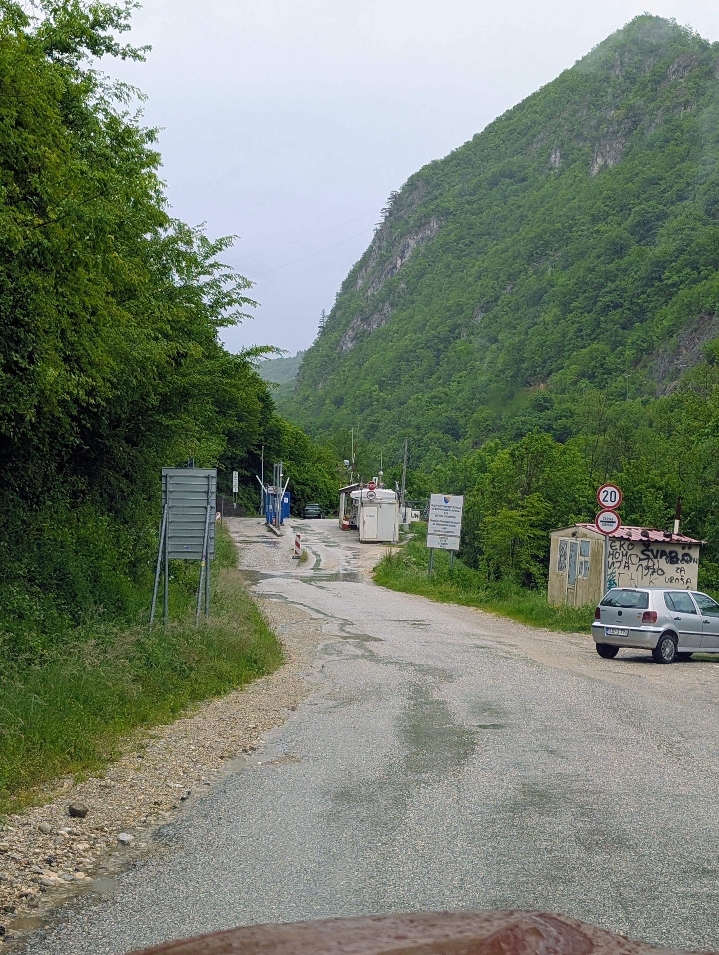 Narrow damaged road with an improvised border crossing