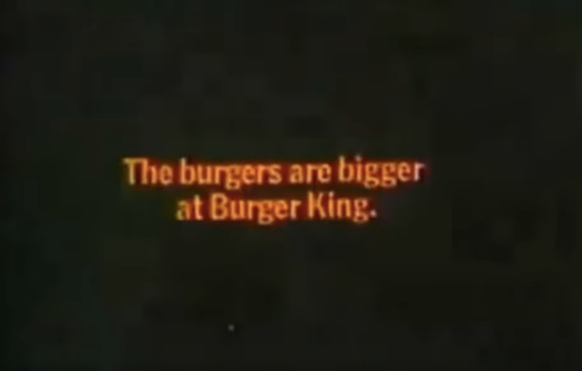 A screenshot from a 1968 Burger King advert that says "the burgers are bigger at Burger King" in orange text on a black background.