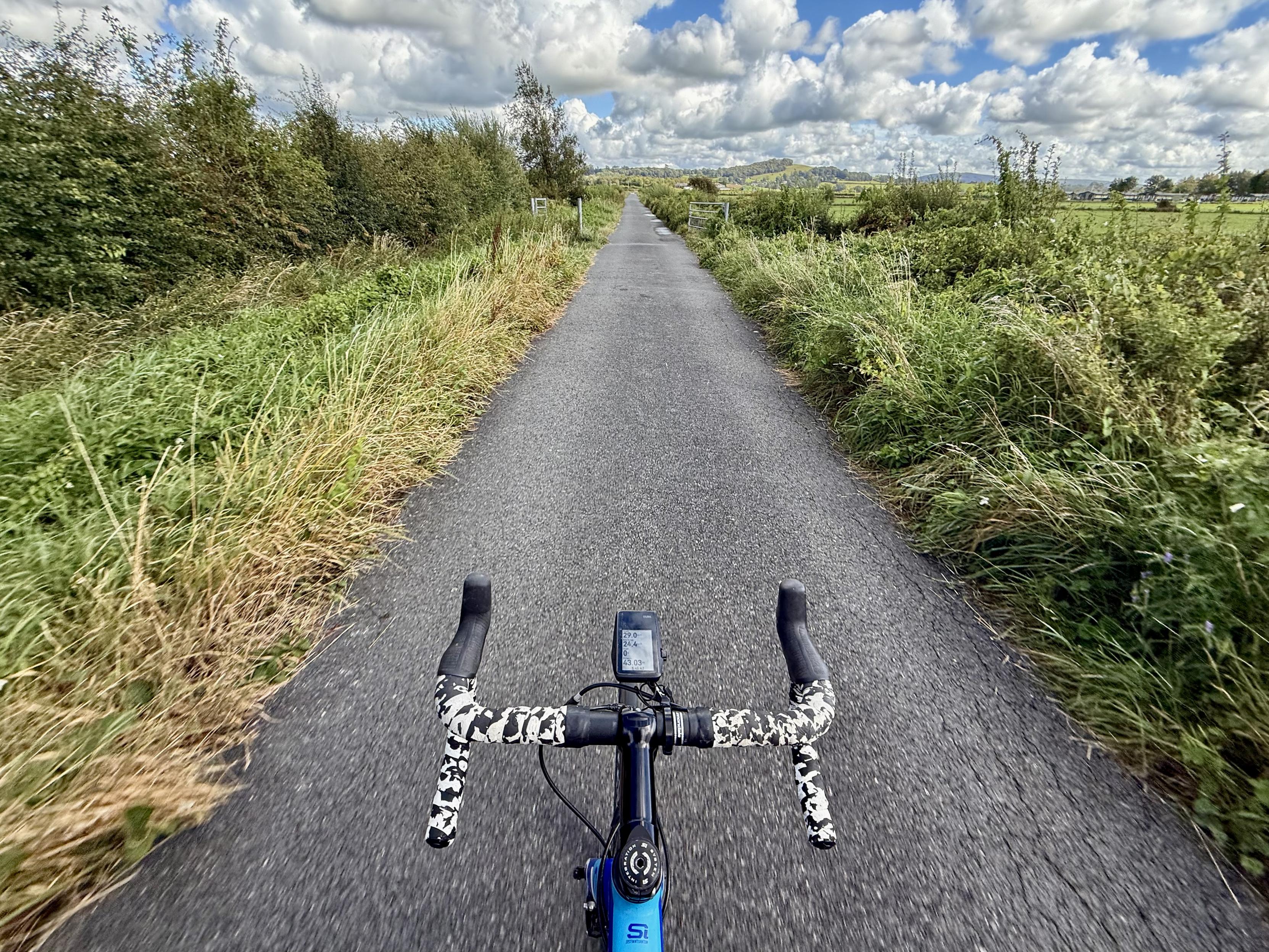 View along a narrow road from behind handlebars